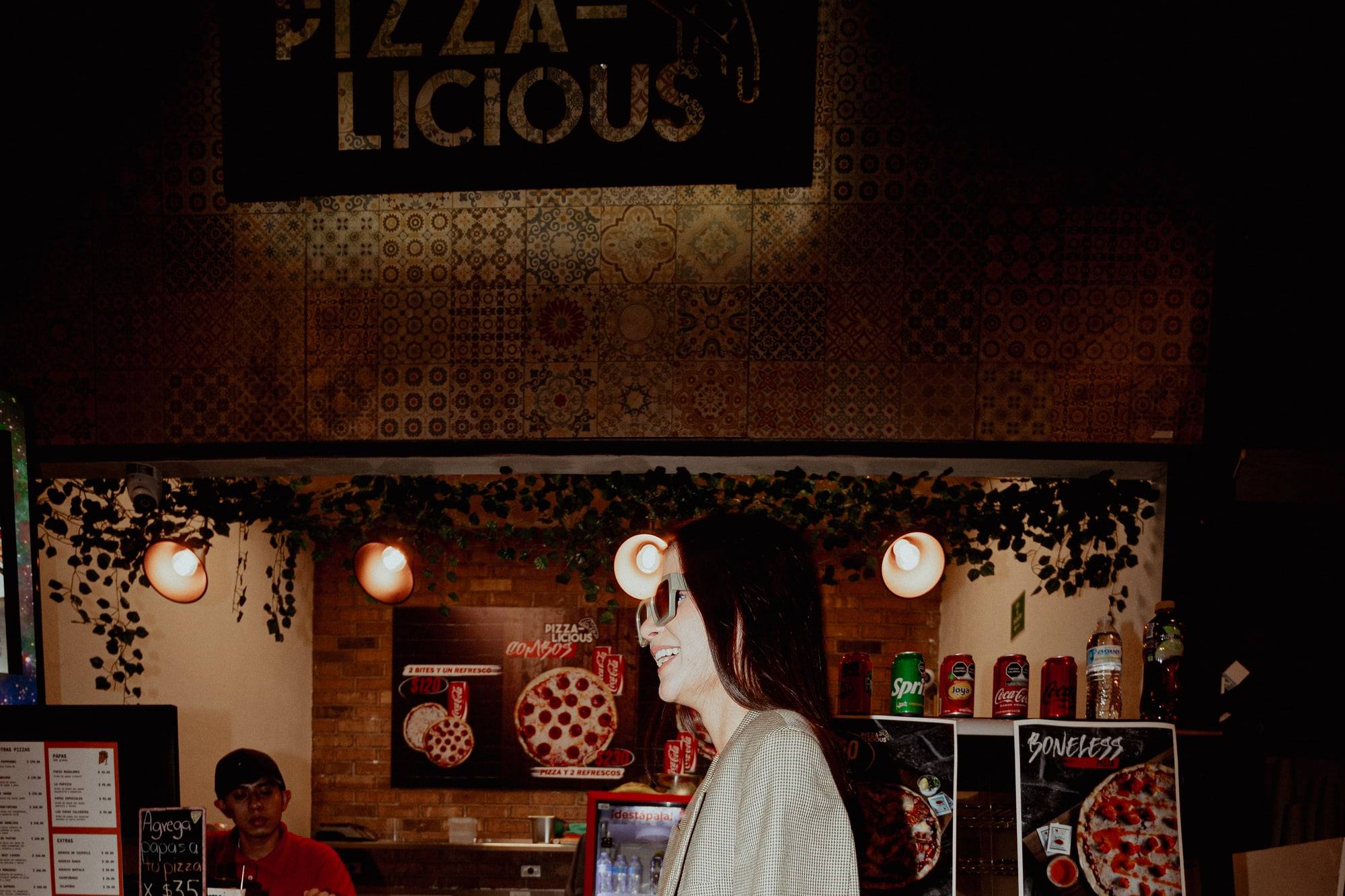 Fachada del local de Pizzalicious dentro del Mercado Barrio Antiguo, con el letrero y la barra de azulejo rojo