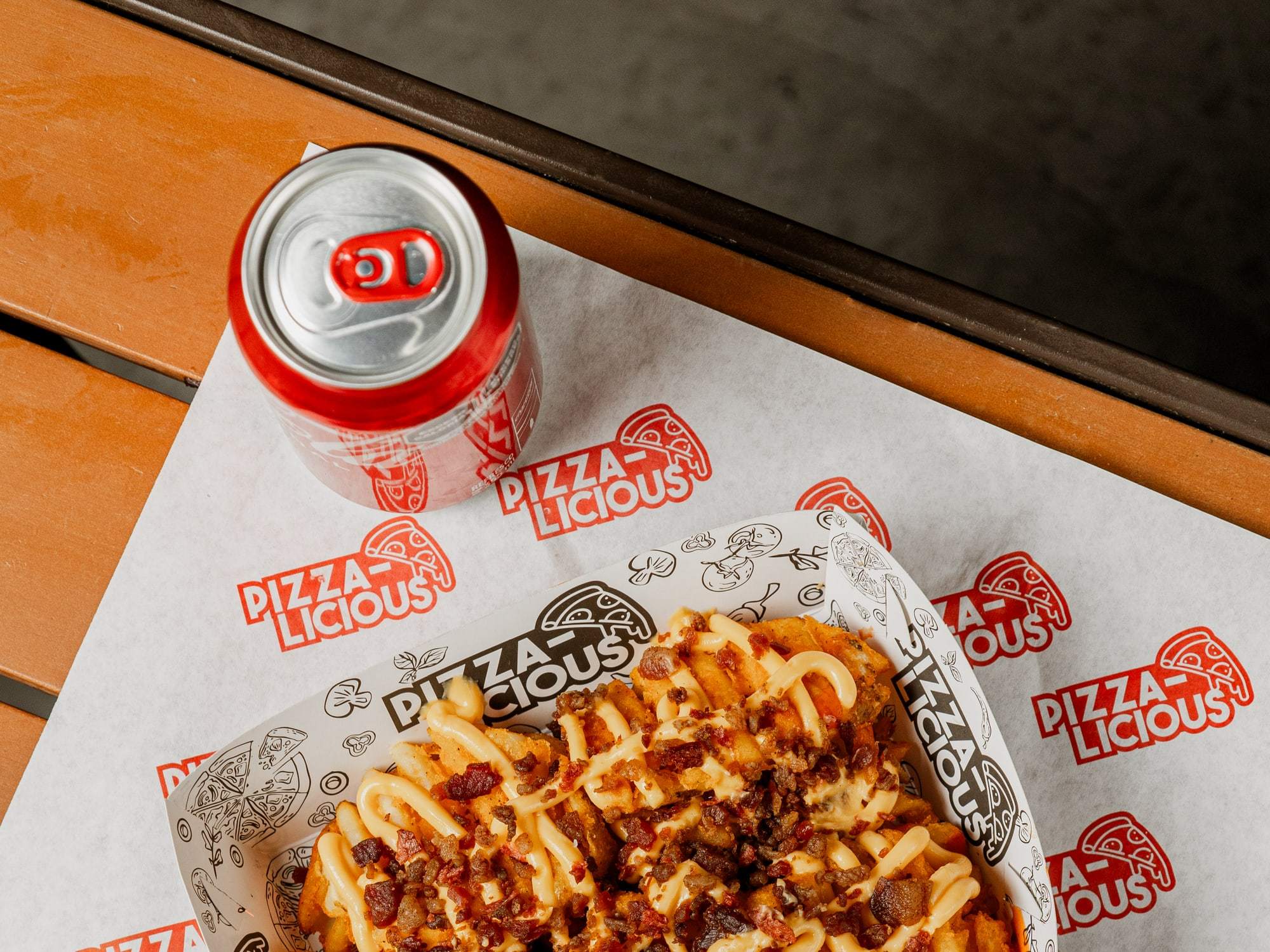 Papas especiales de Pizzalicious con queso amarillo y tocino, con aderezo aparte