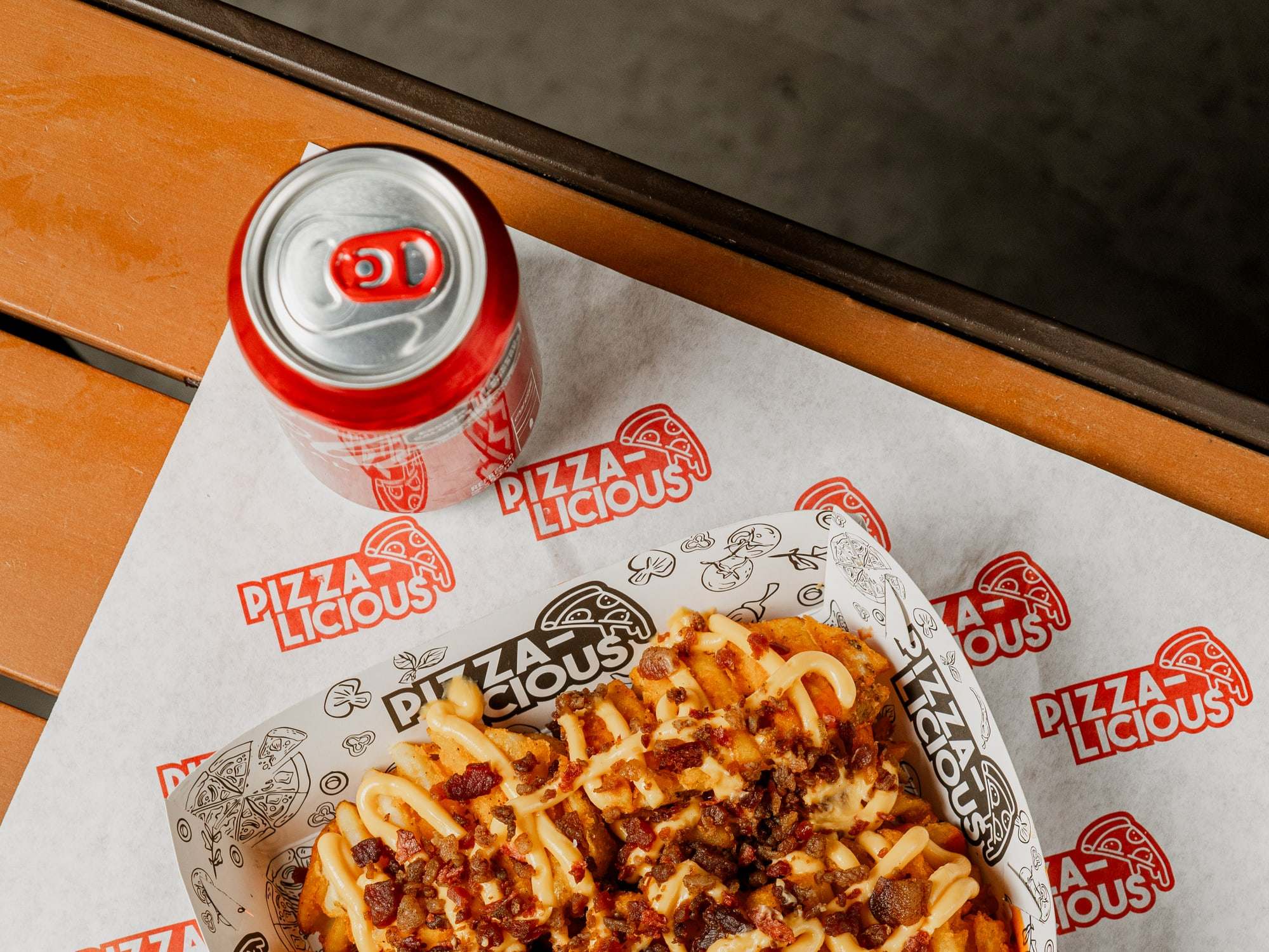 Papas especiales de Pizzalicious con queso amarillo y tocino, con aderezo aparte